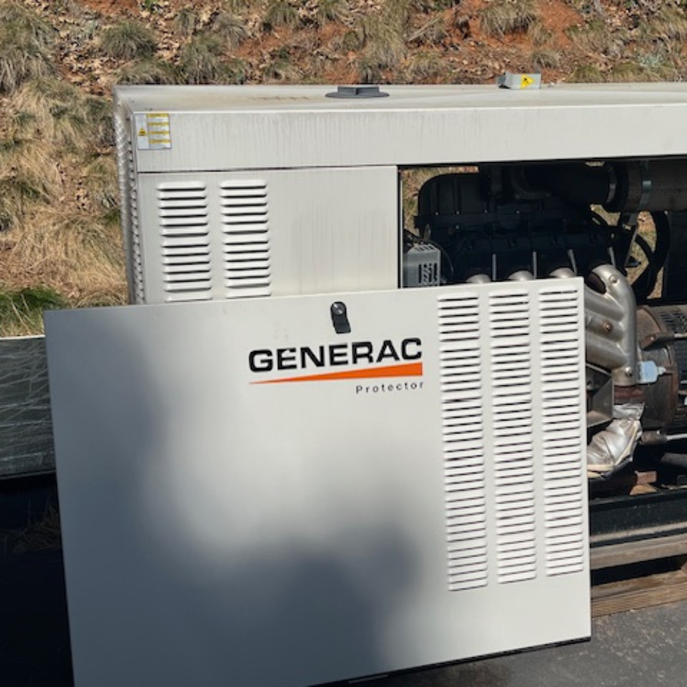 Generac Protector industrial generator with side panel removed, exposed engine components outdoors.